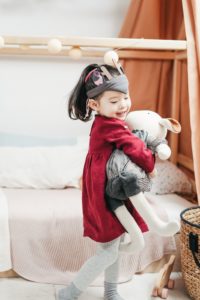 Play House to Practice Social Lanugage Smiling girl holding stuffed bunny