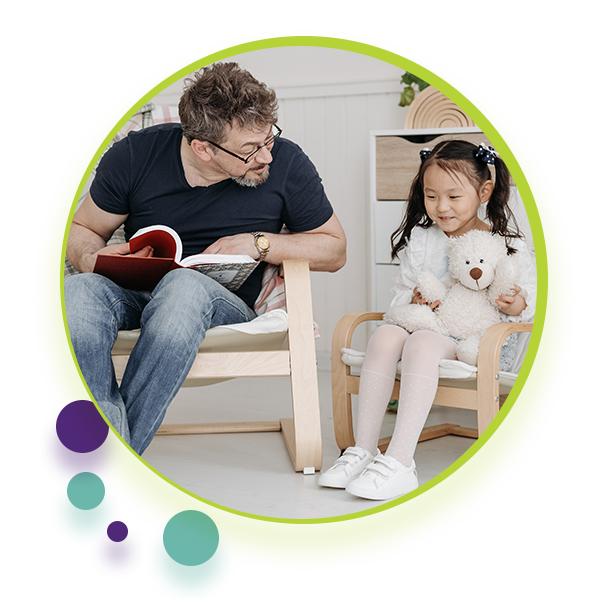 Social Worker and child sitting next to eachother, reading a book. - Decorative image for Communication Clubhouse Therapy Social Work Page