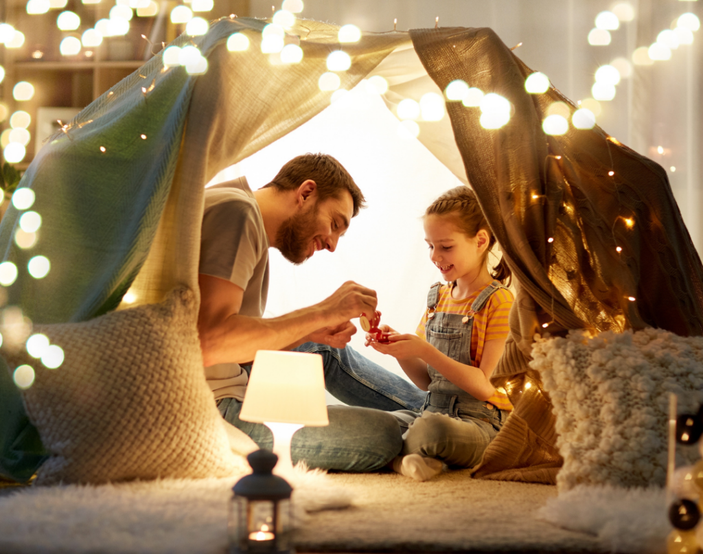 dad and daughter working on language skills in blanket fort