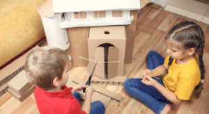 kids playing with cardboard box house