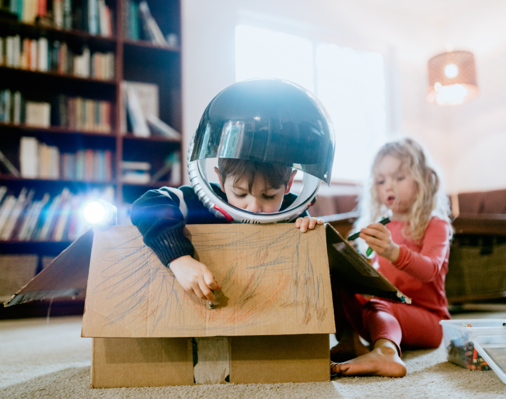 kids using language skills and playing inside cardboard box