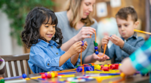 kids stringing beads to improve pencil grasp