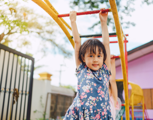 child utilizing proprioception on monkey bars