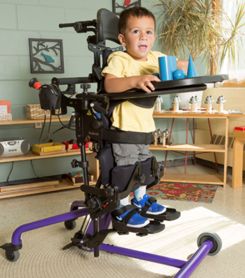 child using standing frame for therapy